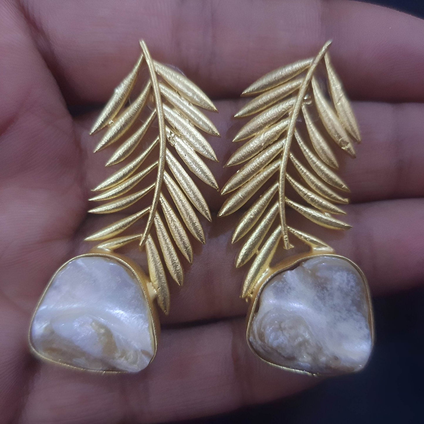 Gold-plated palm leaf earrings featuring a unique design with natural stone accents