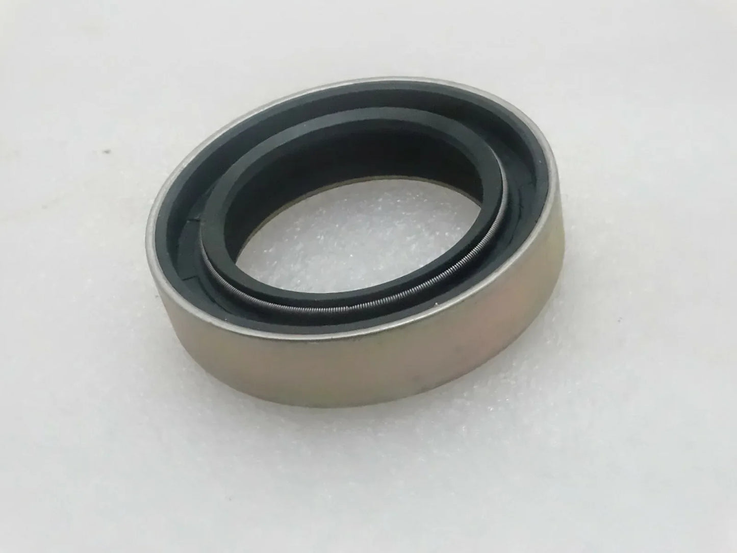 Oil seal with beige housing and dark rubber sealing lip ring