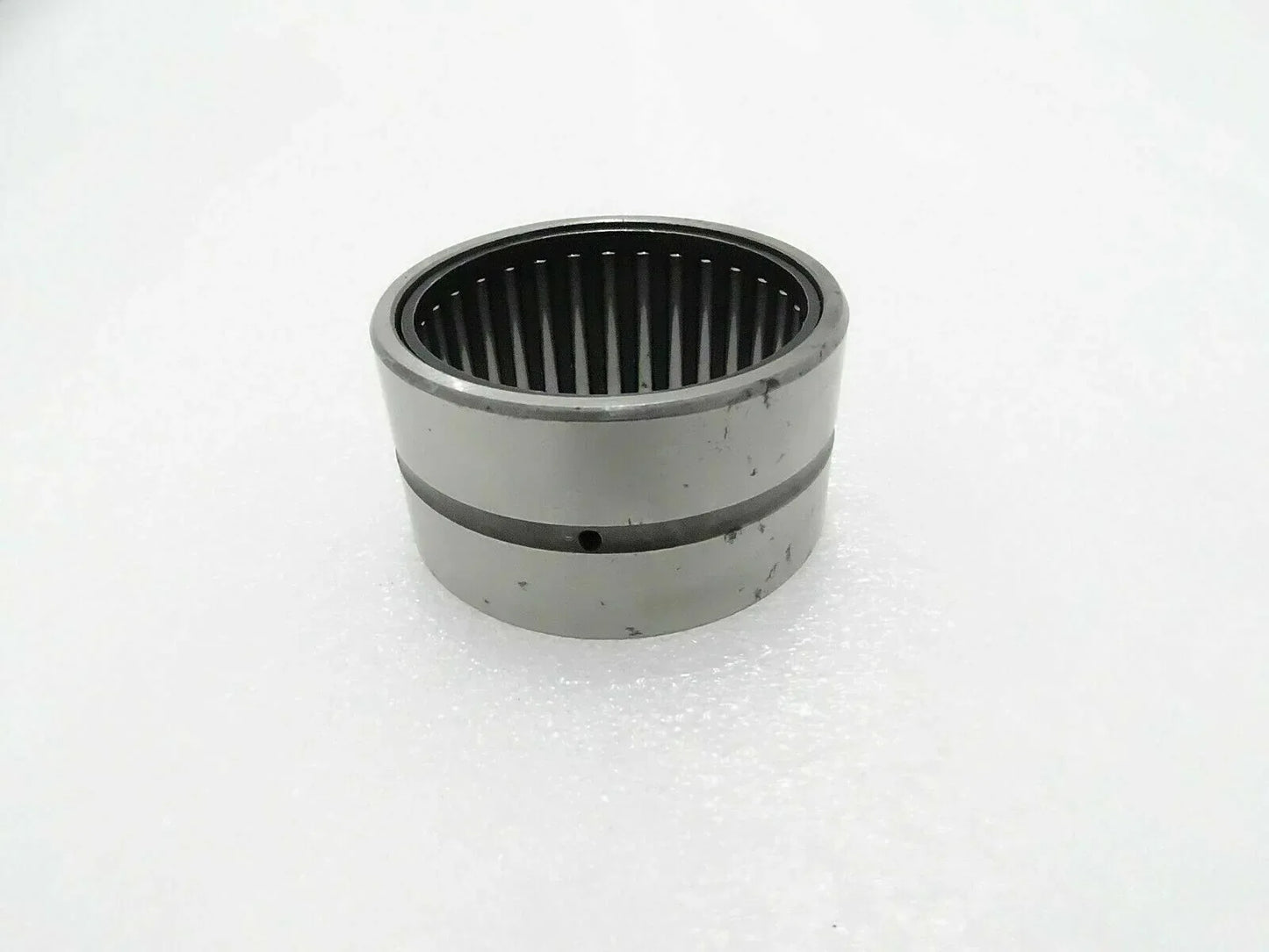 Needle bearing bushing with cylindrical metal housing and inner roller cage