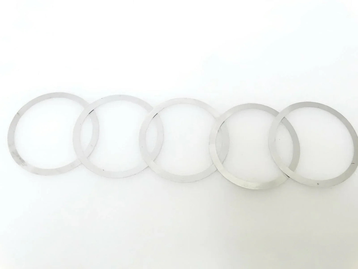 Shim kit: set of thin circular washers and rings, light gray