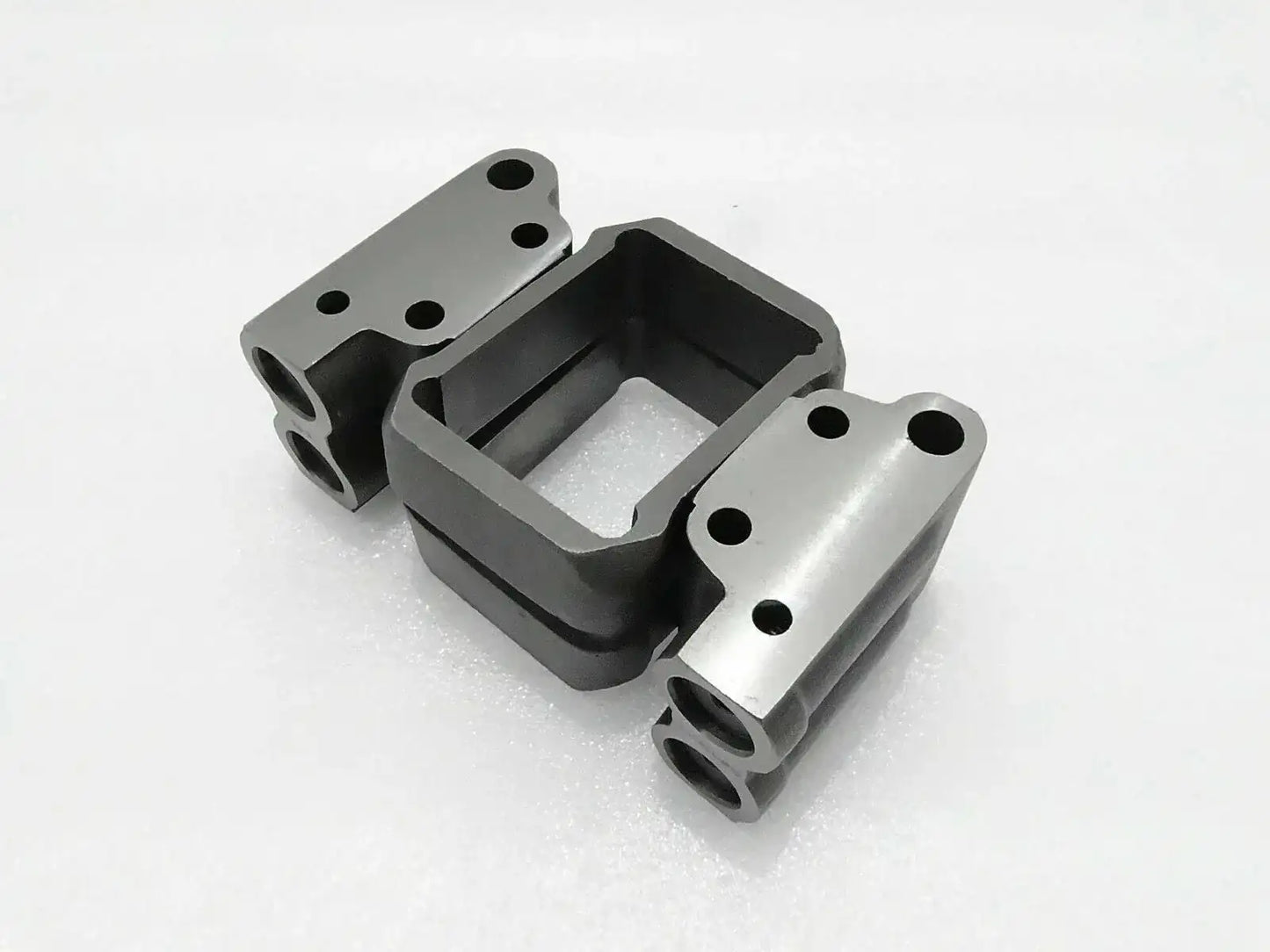 Hydraulic pump valve block with mounting flanges, metal and black finish.