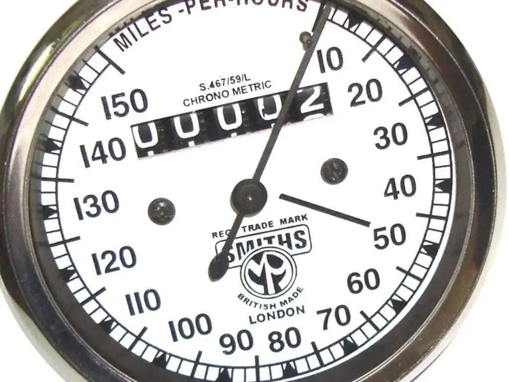 Vintage speedometer dial with white face, 0–150 mph scale.