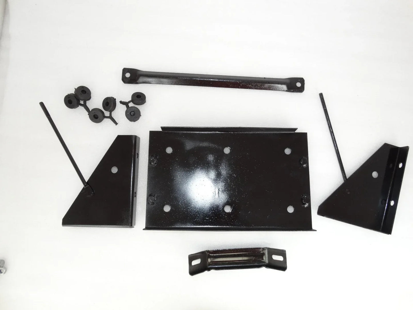 Vintage battery stand assembly parts: black metal brackets, plates, and hardware pieces