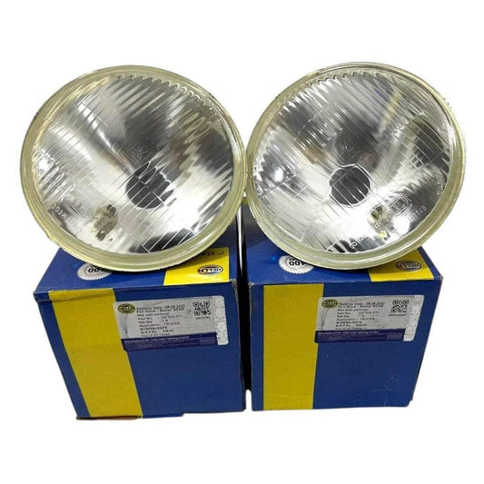 Hella 7-inch headlight lamp pair with clear glass lenses, chrome bezels