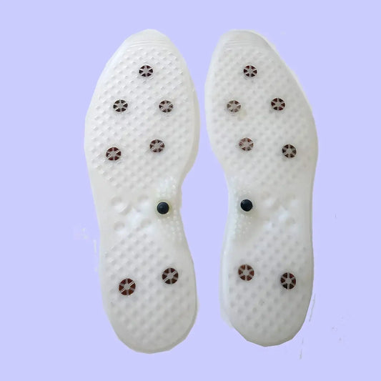 White acupressure shoe insoles with metal studs and small black magnet tabs