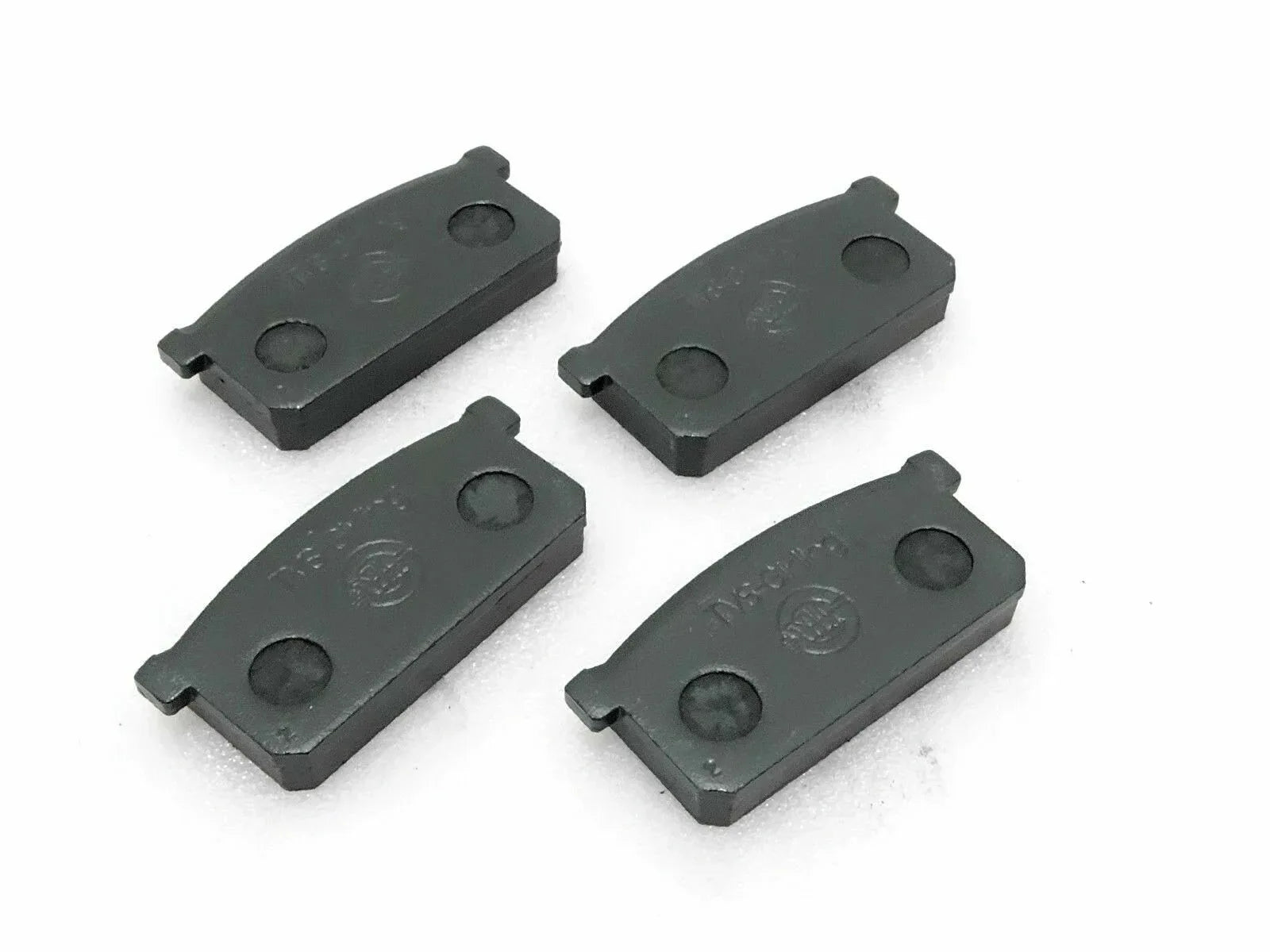Front brake pad set of four, dark gray metal pads with mounting tabs