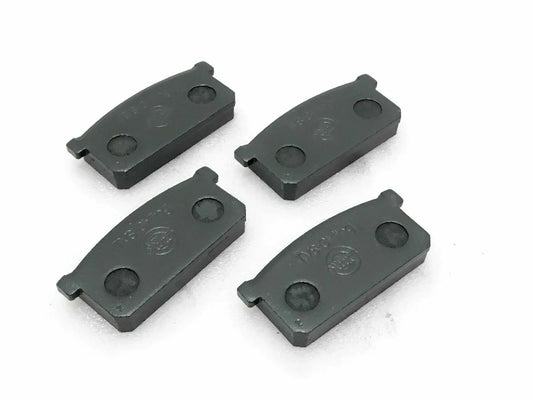 Front brake pad set of four, dark gray metal pads with mounting tabs
