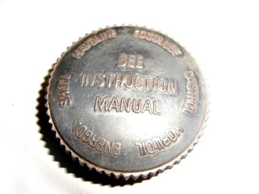 Metal oil tank filler cap with embossed instruction manual text