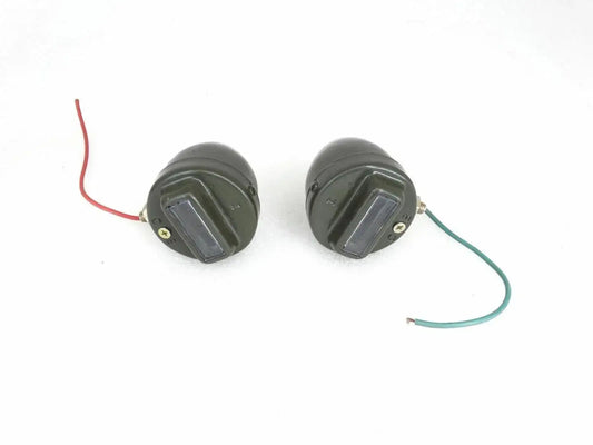 Round cat-eye marker light pair with black housings and front lenses, side view