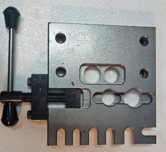 Gray metal holding plate fixture with bolt holes and central cutout
