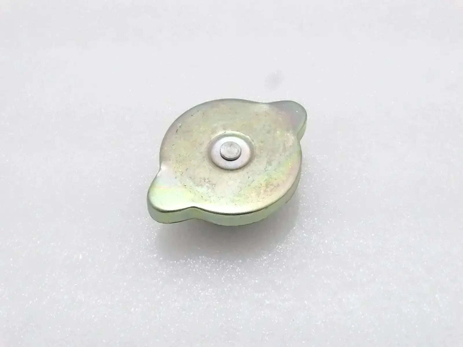 Light green metal radiator cap with circular center and mounting tab