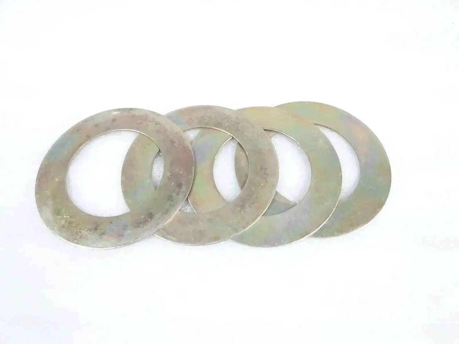 Round metal shim washers with central holes, greenish and worn finish