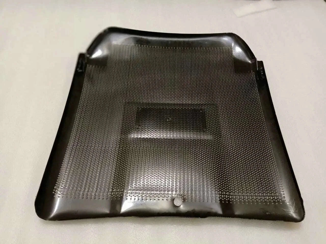 Front grill panel with perforated mesh and central rectangular opening, dark gray