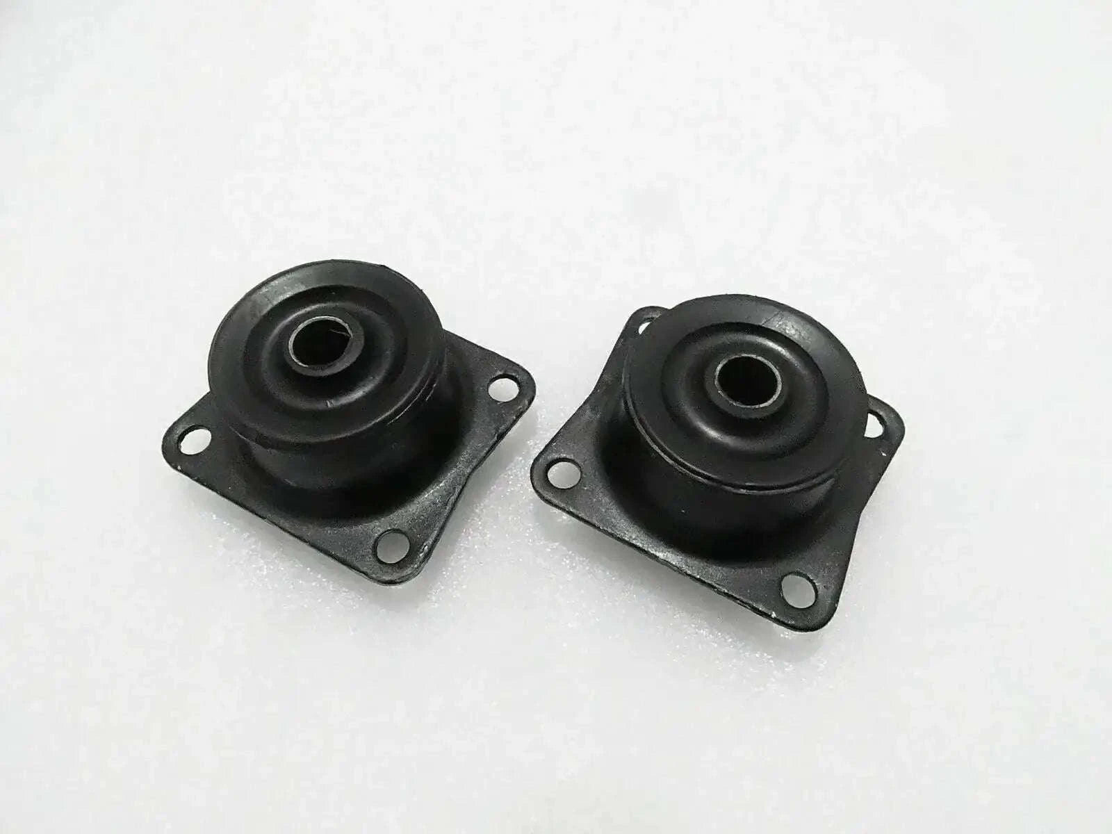 Pair of black rubber mounts with metal plates, mounting holes, and central eyelets