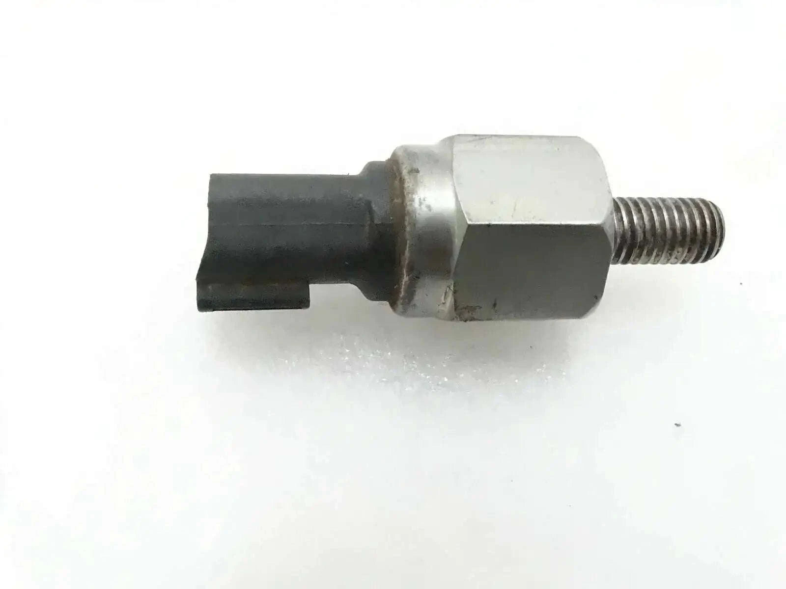 Oil pressure switch with hex metal body, black connector, and threaded stud