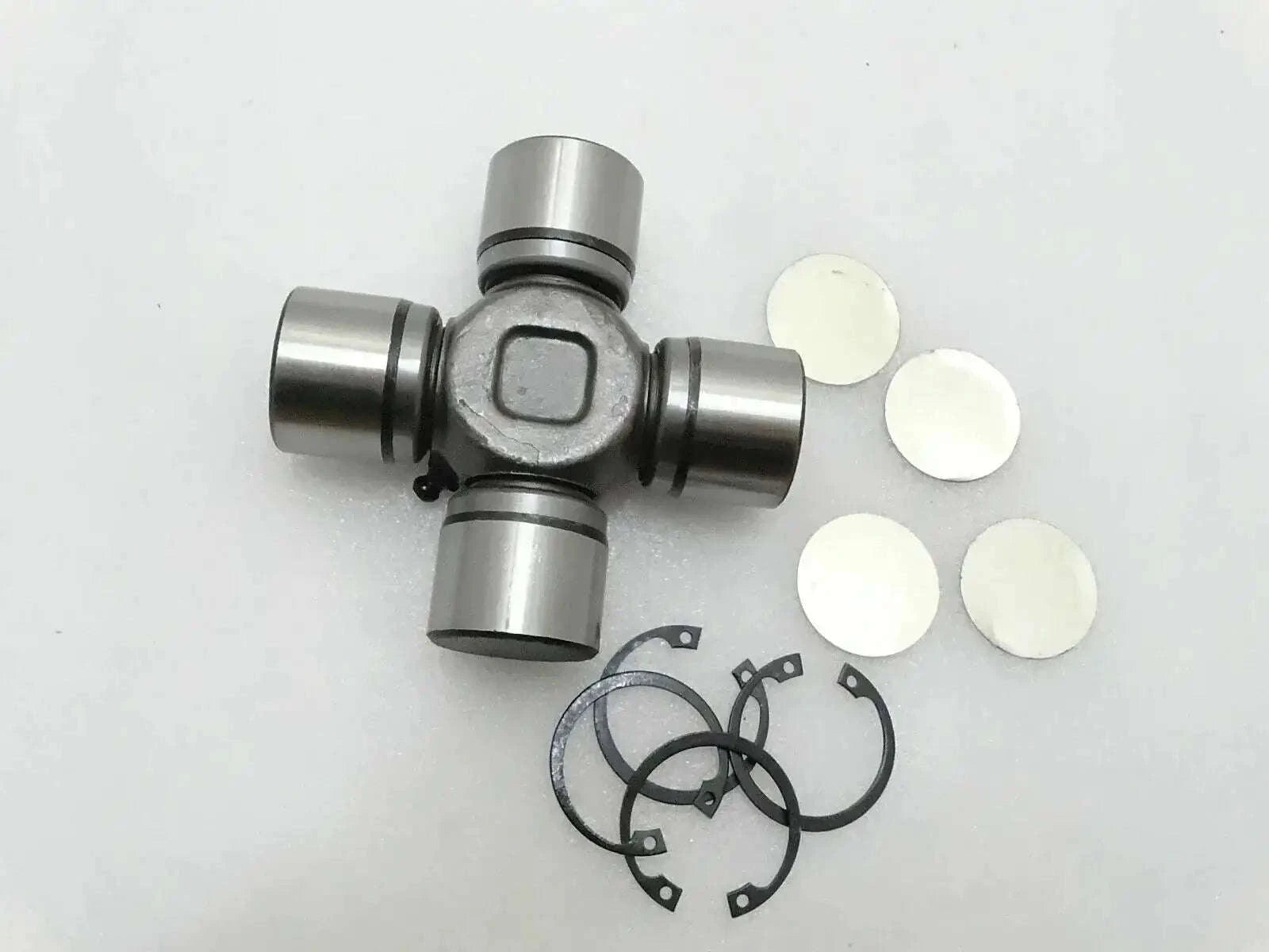 Universal joint with metal yokes, retaining rings, and white spacer washers