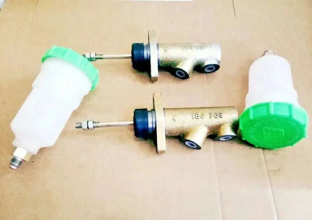 Brake master cylinder pair with green reservoirs and metal mounting fittings