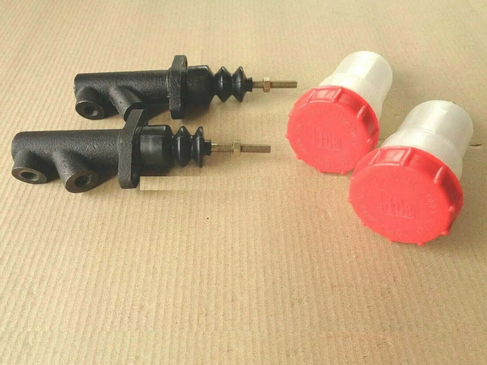 Brake master cylinder with reservoir set: two black units with red reservoirs and white caps