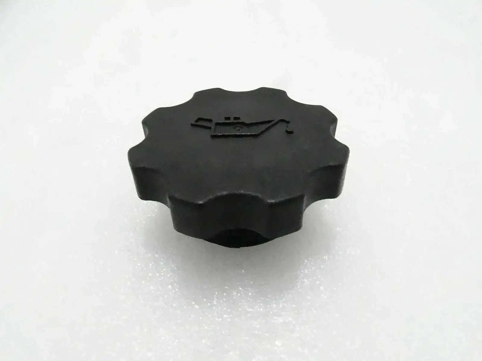Black engine oil filler cap with ridged circular top and embossed pull tab
