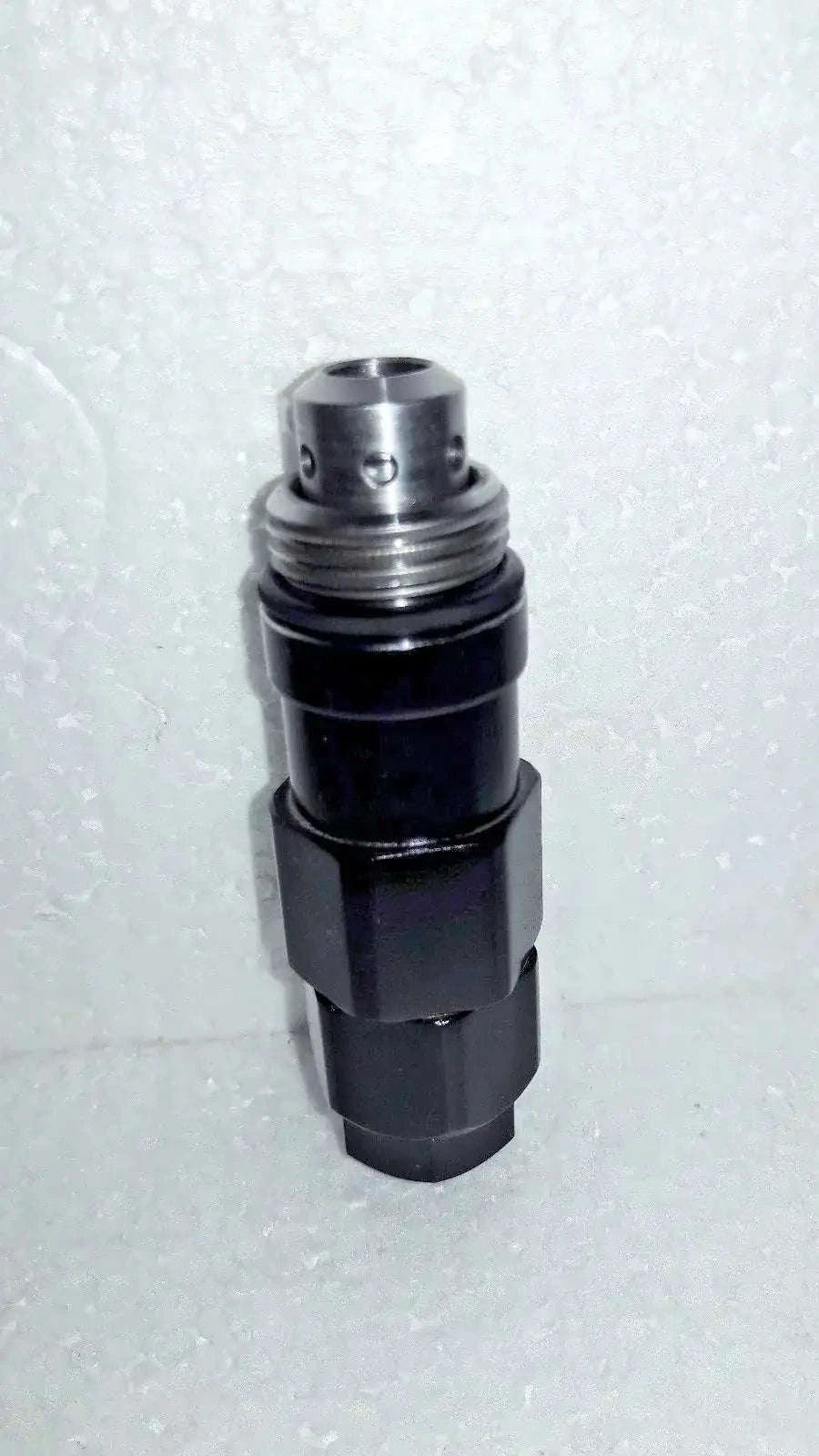 Hydraulic relief valve with silver metal top and black cylindrical body