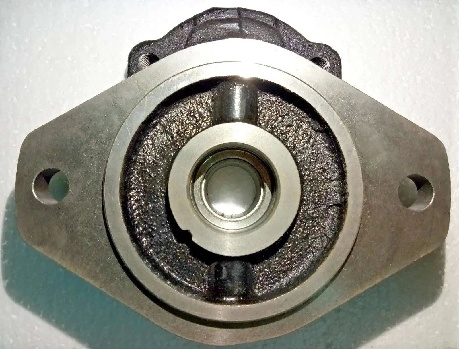 Hydraulic pump mounting flange with central bearing seal, metal body with side bolt holes
