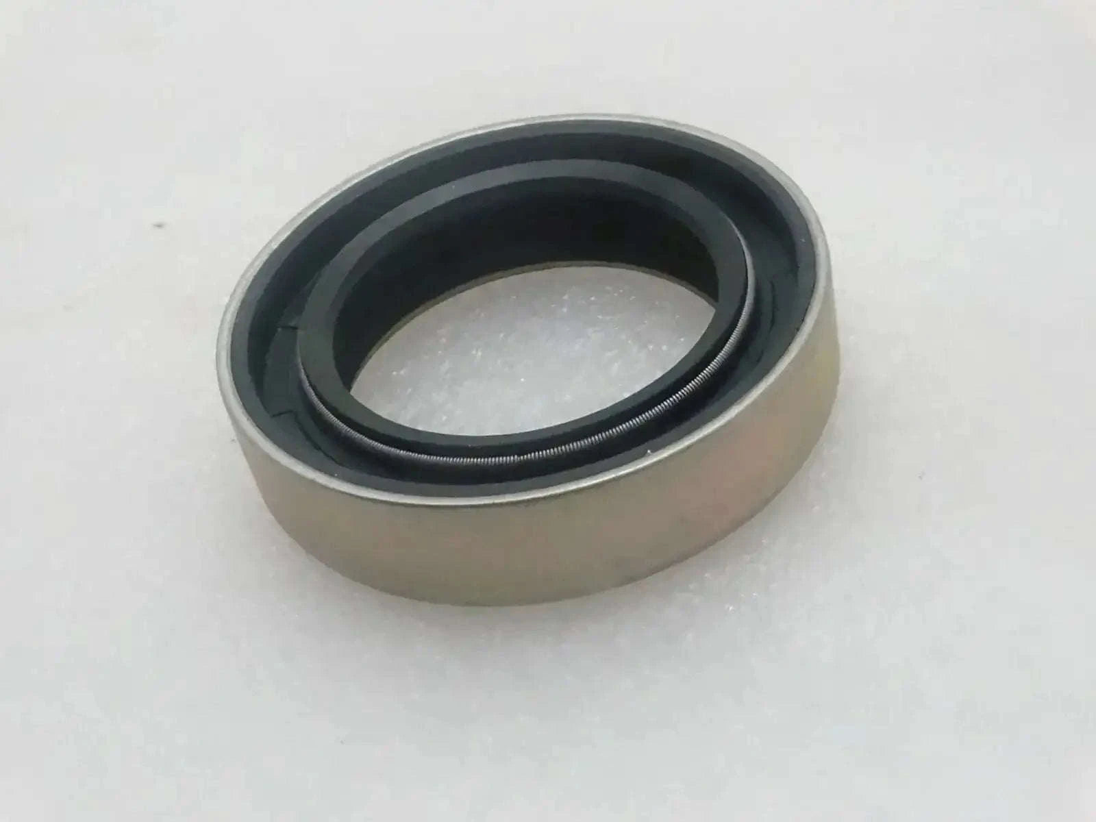 Oil seal with beige housing and dark rubber sealing lip ring
