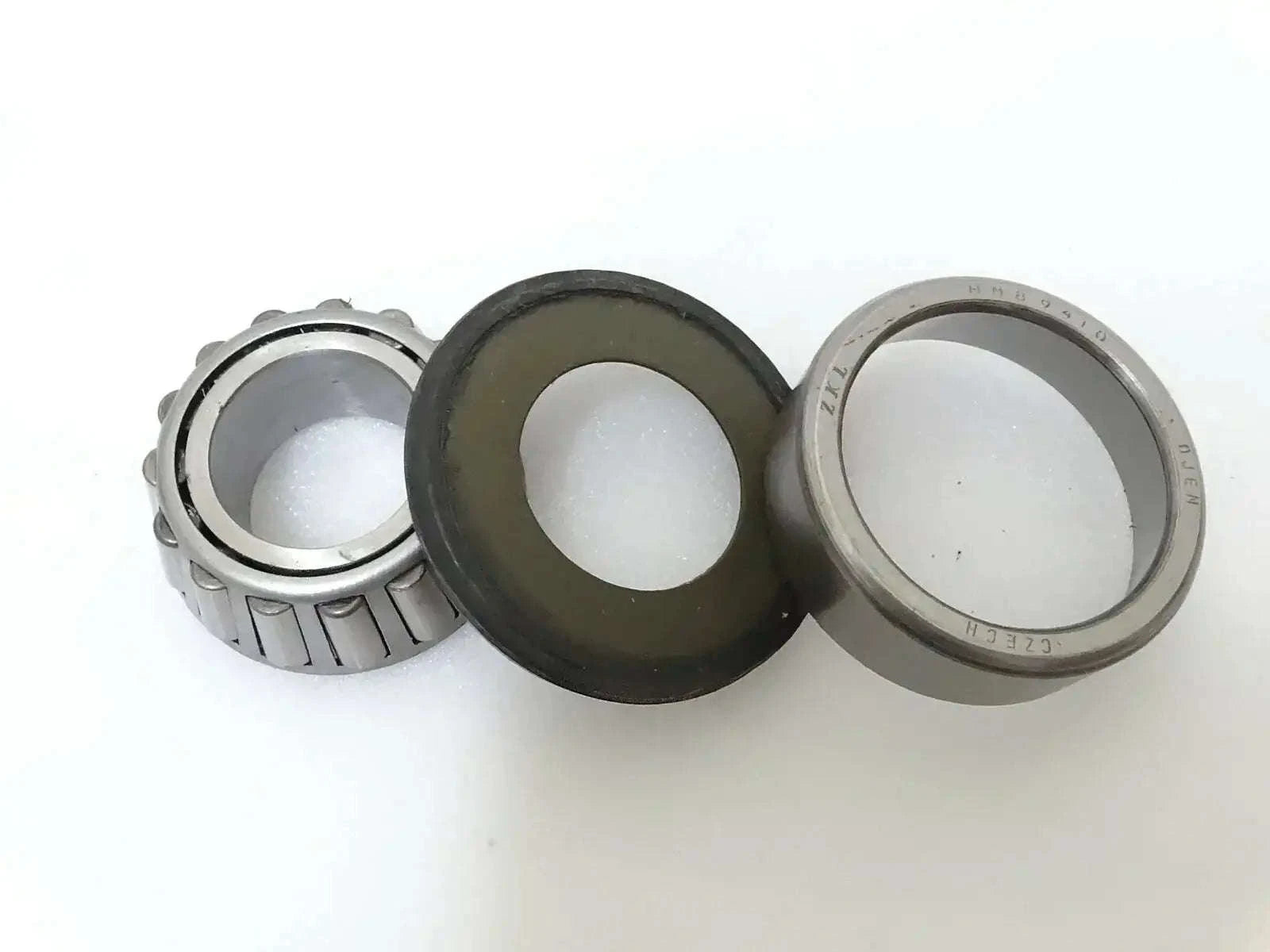 Steering knuckle trunnion bearing and seal set with metal rings and black rubber seal