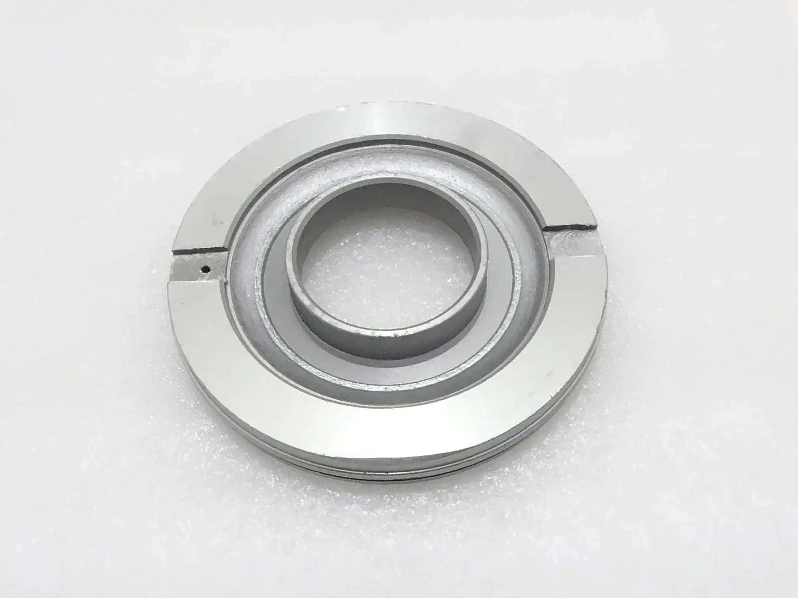 Metal piston assembly part with circular inner bore and outer ring, silver-gray