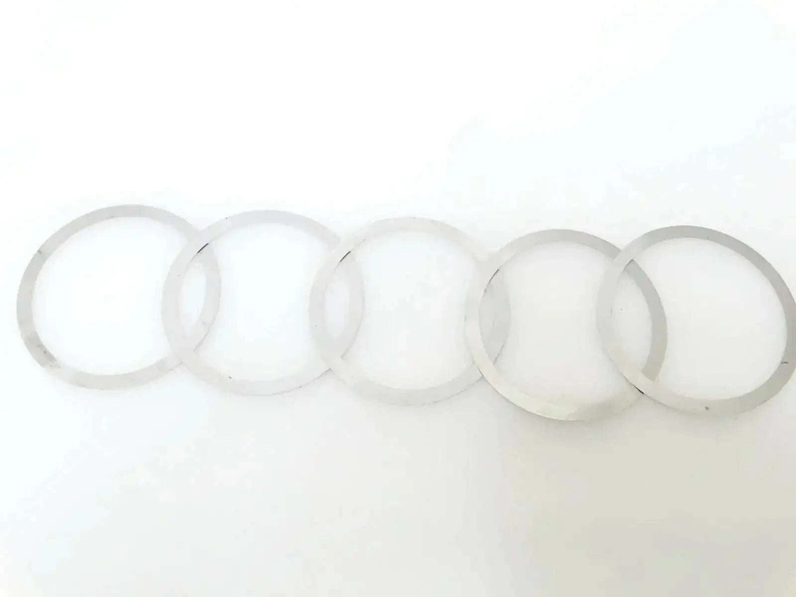 Shim kit: set of thin circular washers and rings, light gray