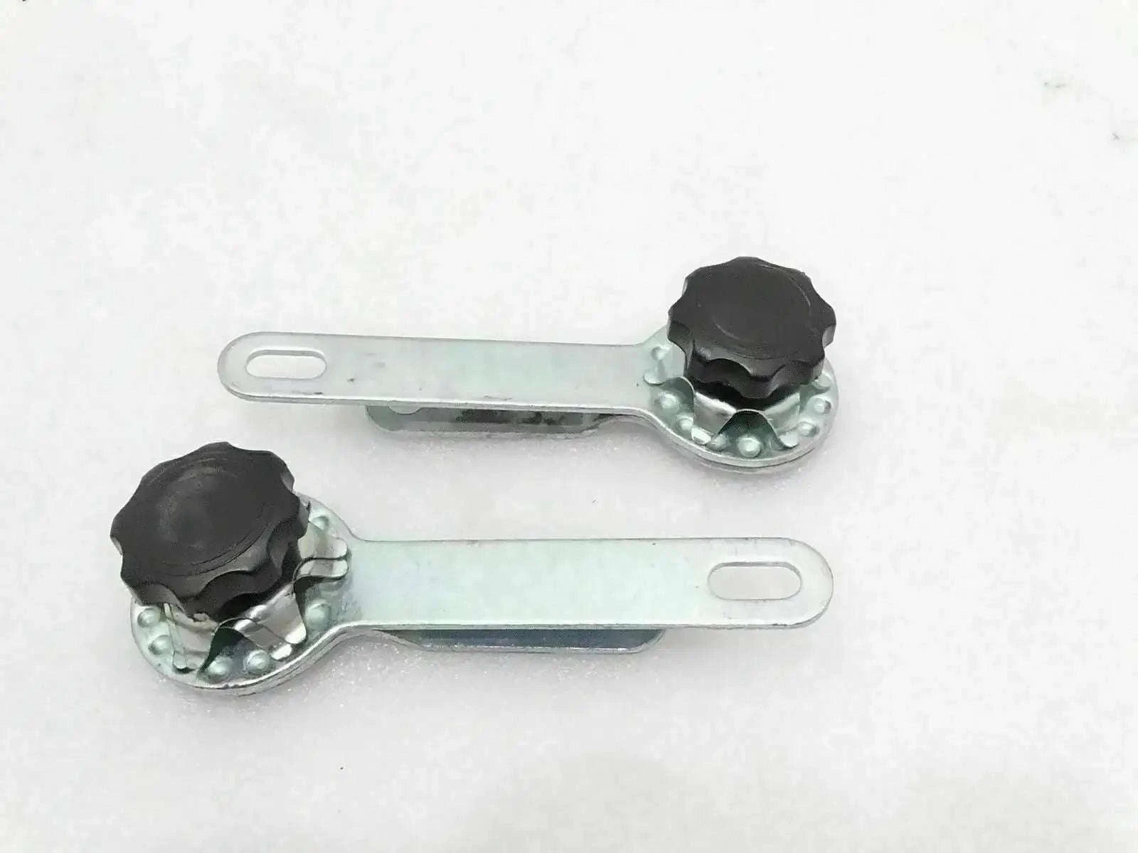 Windshield frame holding adjustment arms with black knobs, metal brackets