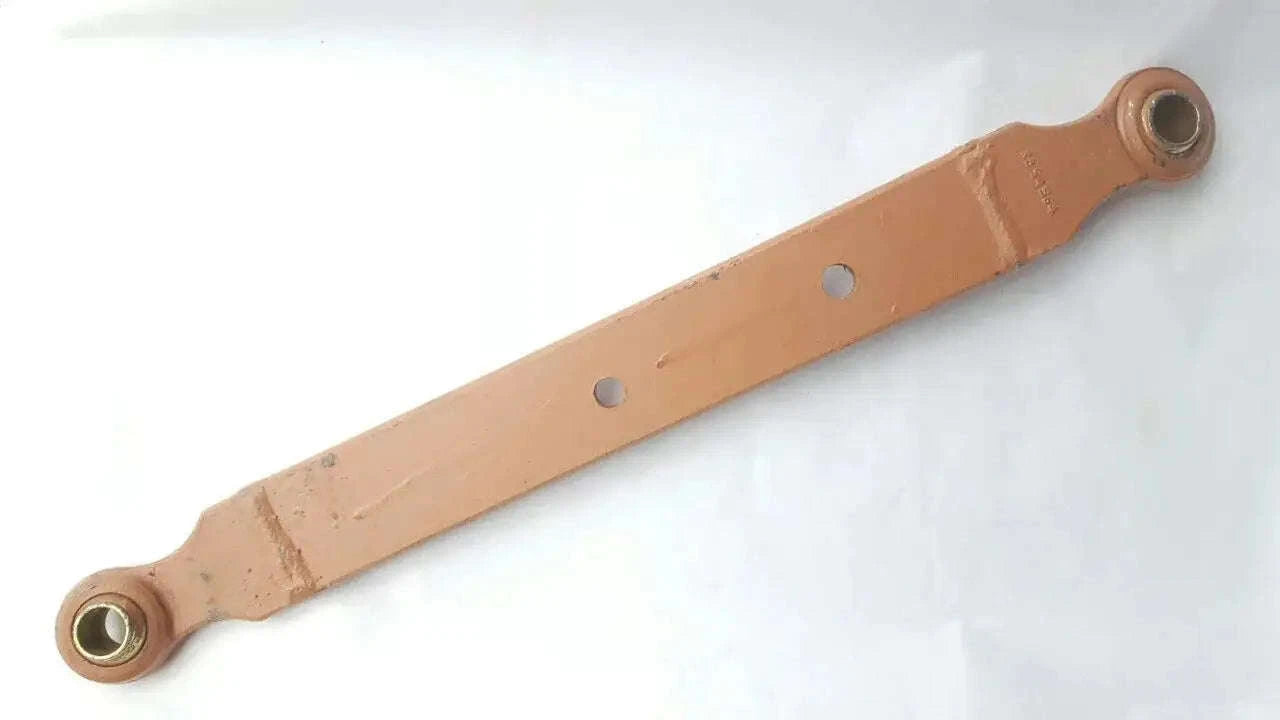 Tractor lower link assembly with two eye ends and bolt holes, rust-brown metal bar.