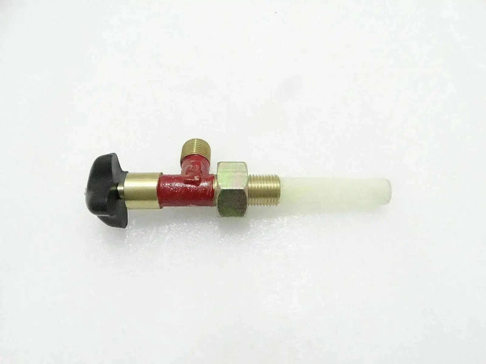 Brass fuel tap with red valve body and white outlet tube