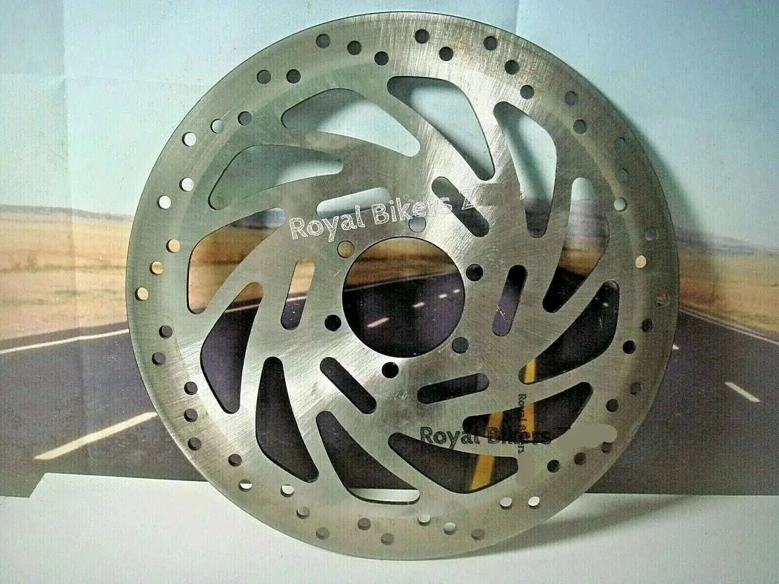Front disc brake rotor, round drilled metal disc with cutouts