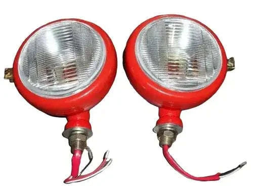 Pair of red tractor headlights with clear round lenses, mounting studs and wiring