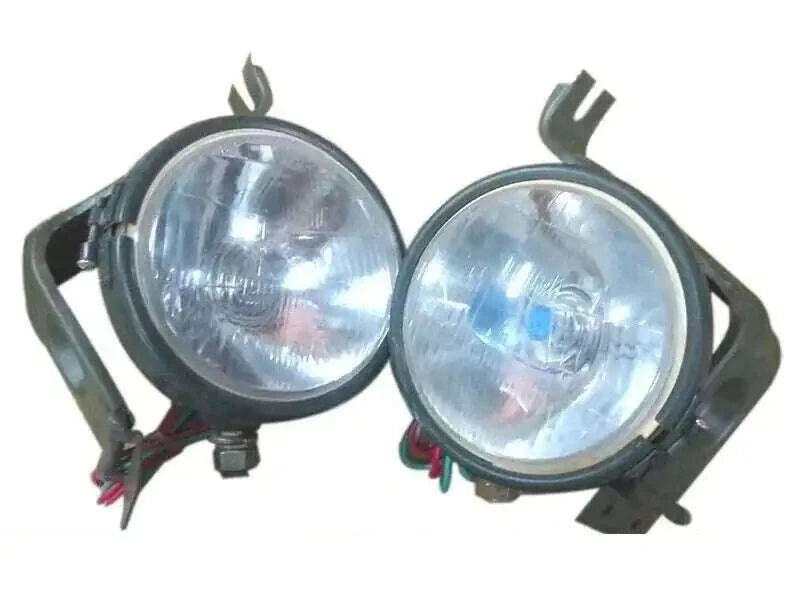 Pair of round vehicle headlights with mounting brackets and wire harnesses