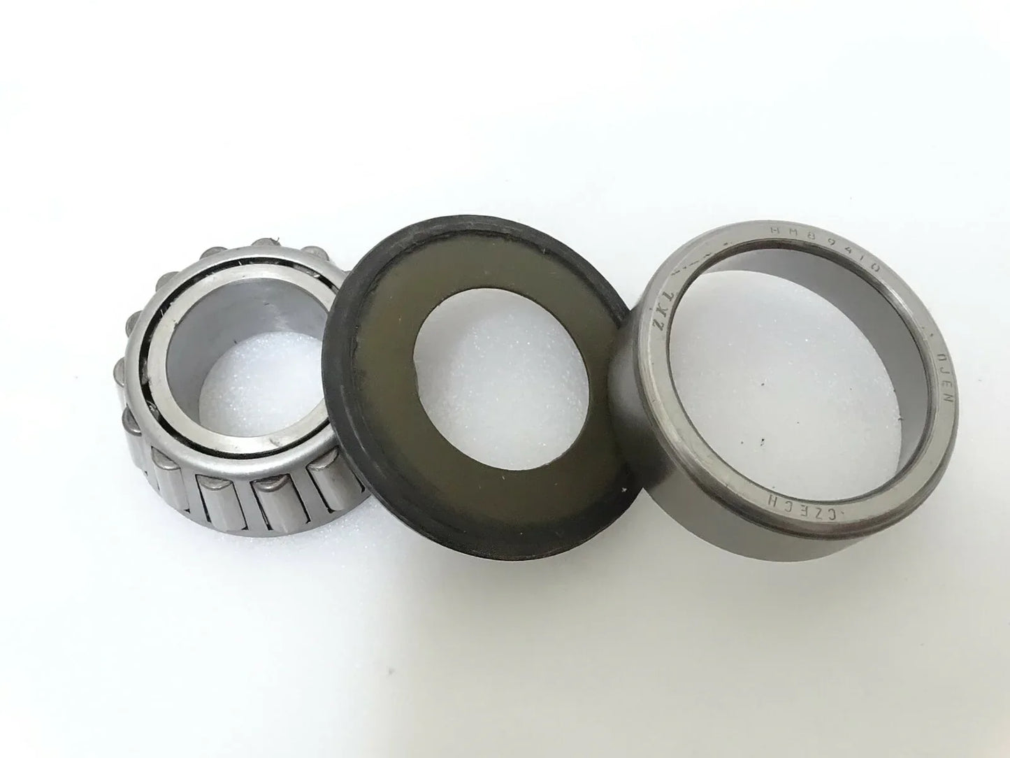 Steering knuckle trunnion bearing and seal set with metal rings and black rubber seal