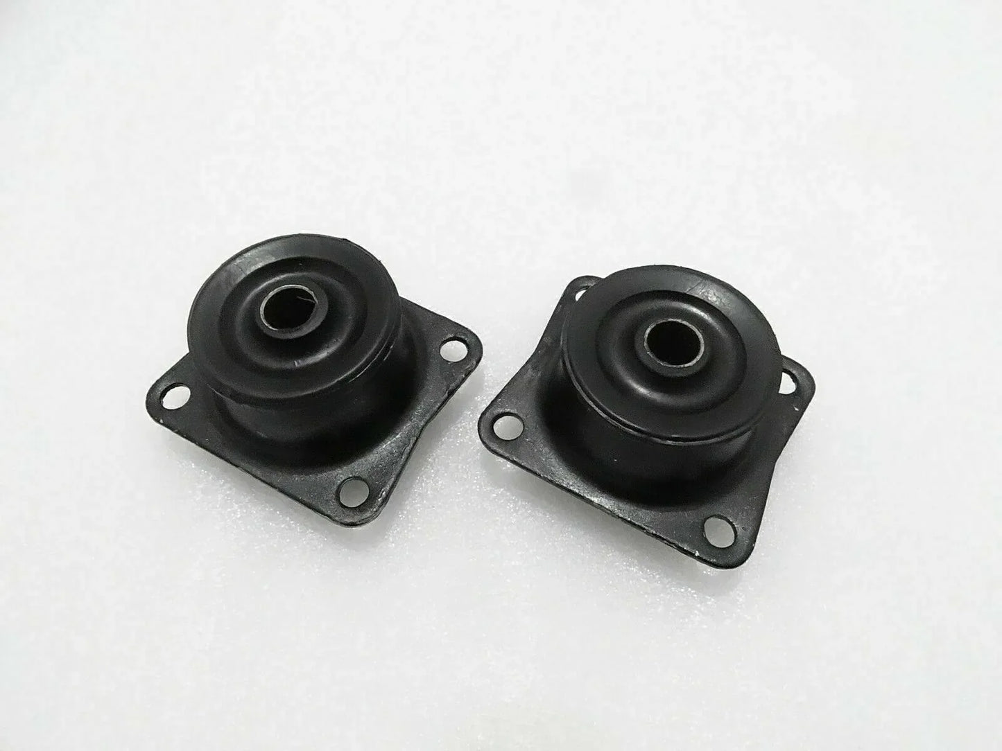 Pair of black rubber mounts with metal plates, mounting holes, and central eyelets