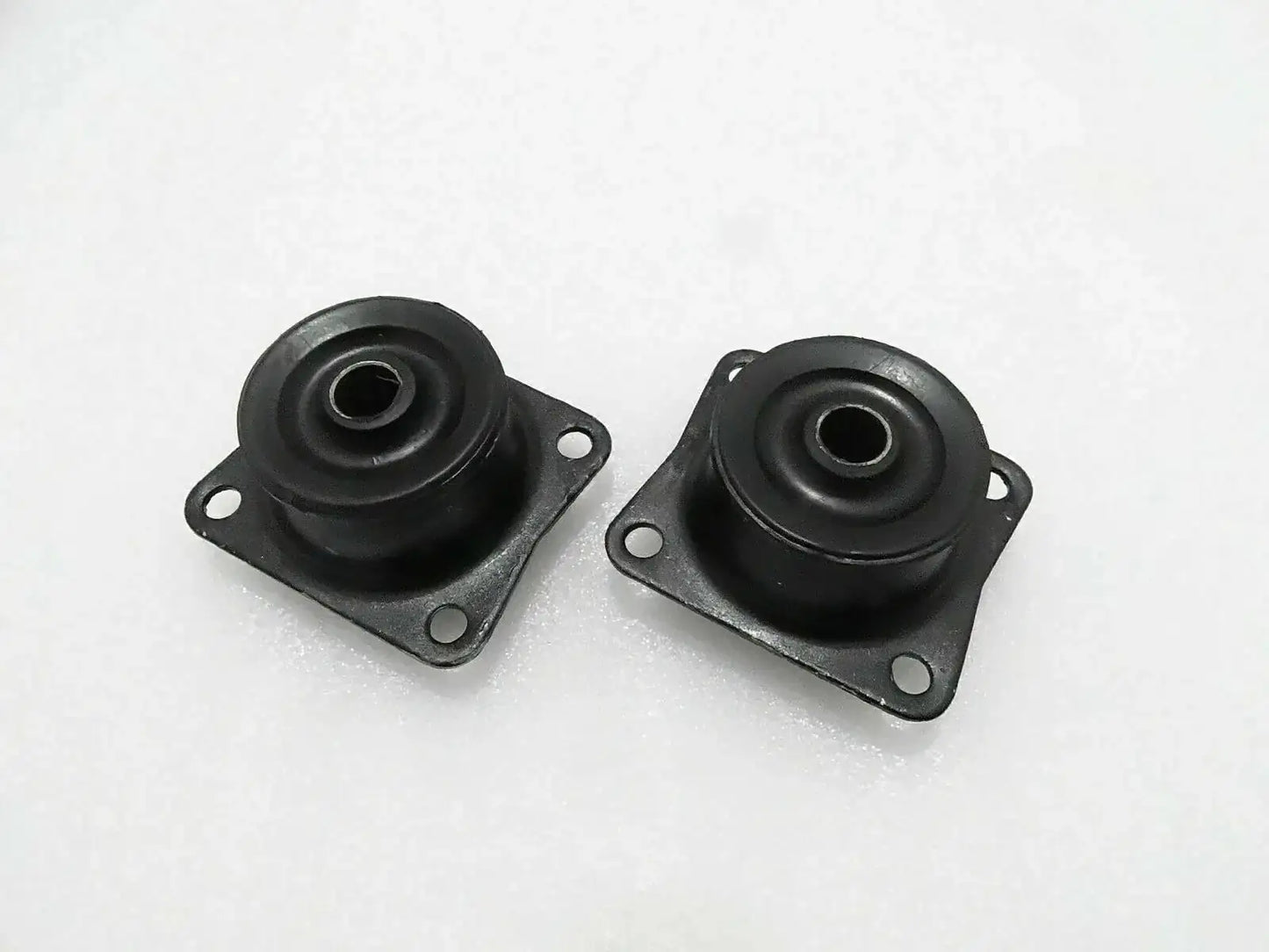Pair of black rubber mounts with metal plates, mounting holes, and central eyelets