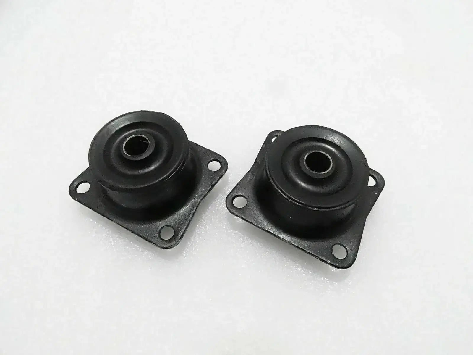 Pair of black rubber mounts with metal plates, mounting holes, and central eyelets