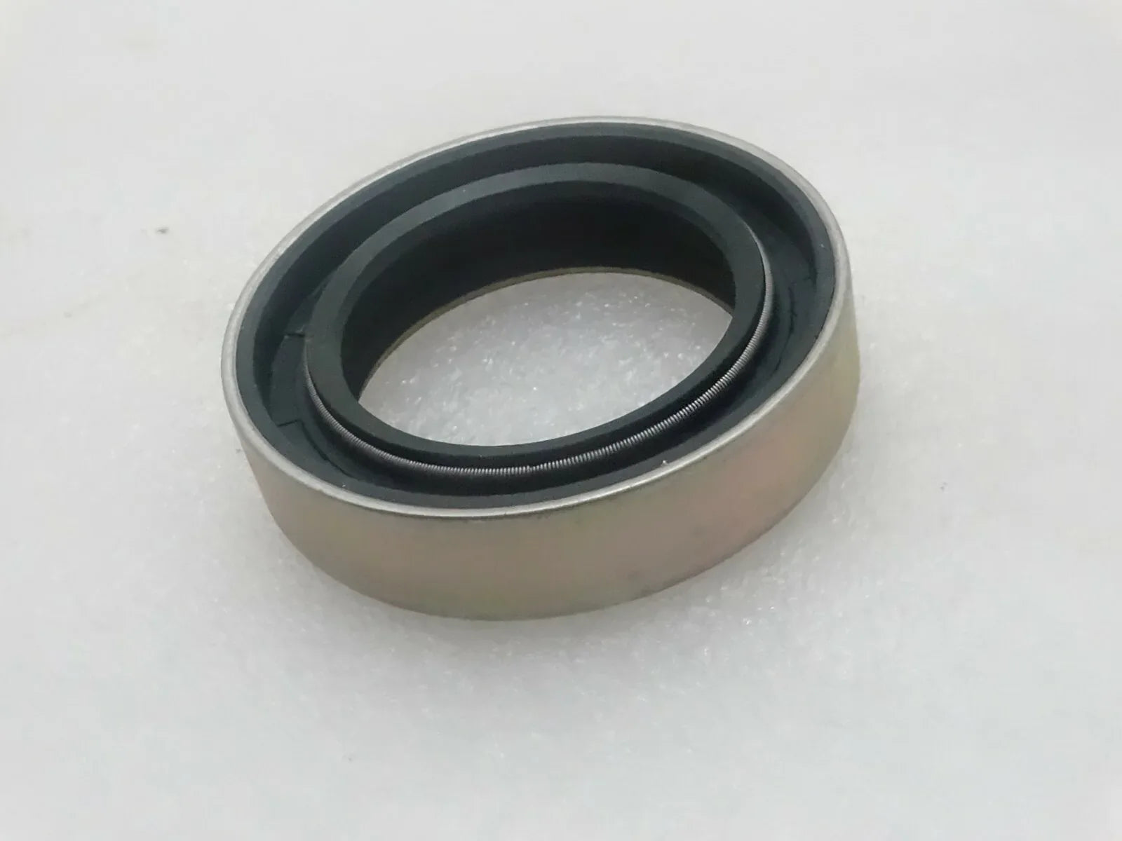 Oil seal with beige housing and dark rubber sealing lip ring