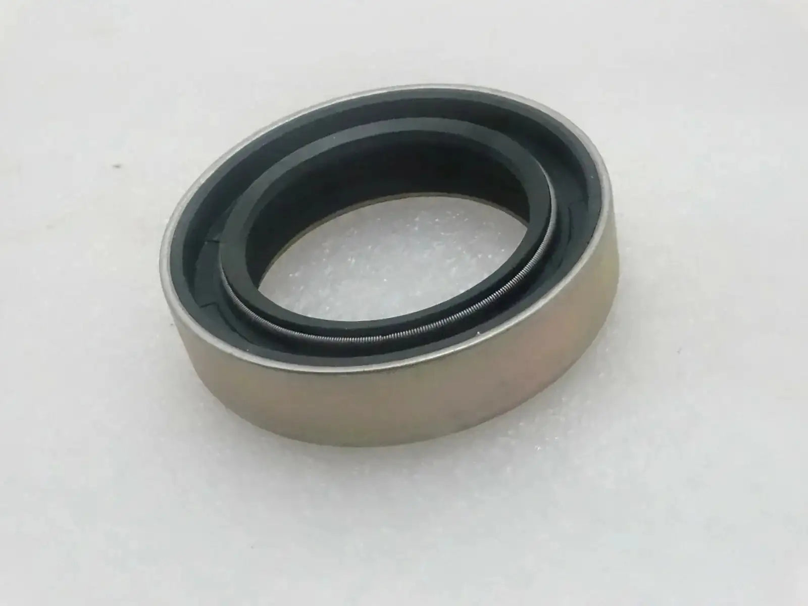 Oil seal with beige housing and dark rubber sealing lip ring