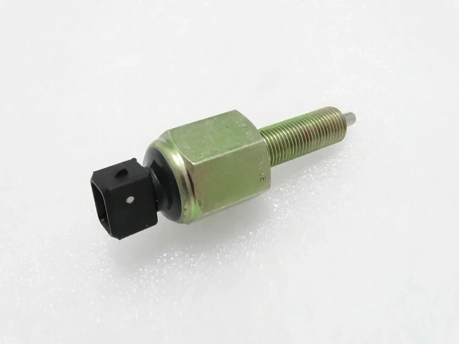 Foot brake switch with green hex body, threaded stud, and black electrical plug