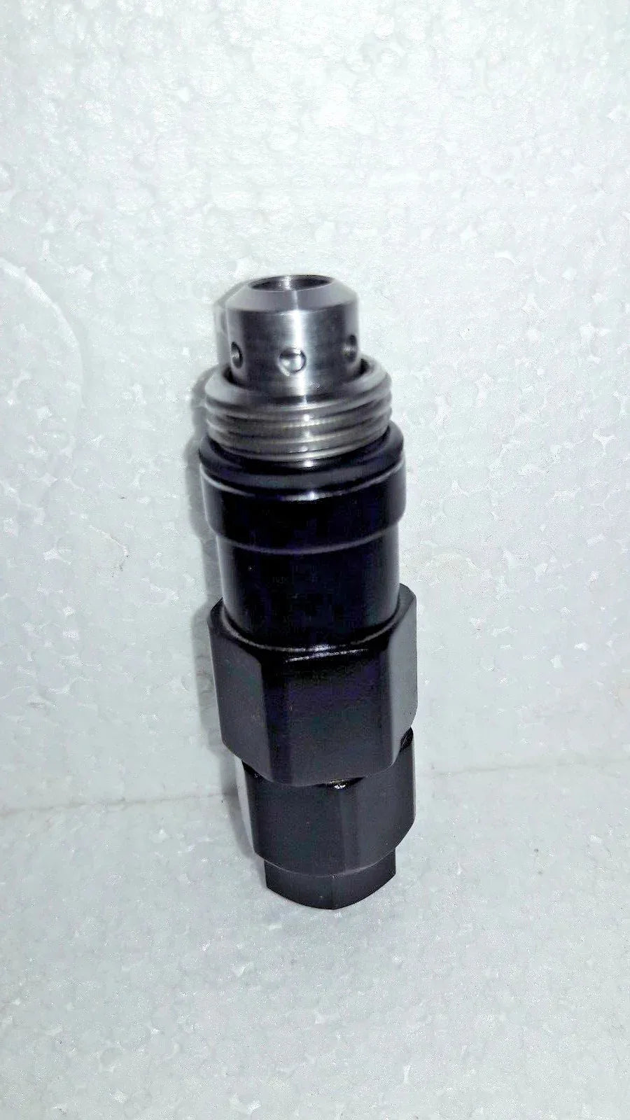 Hydraulic relief valve with silver metal top and black cylindrical body