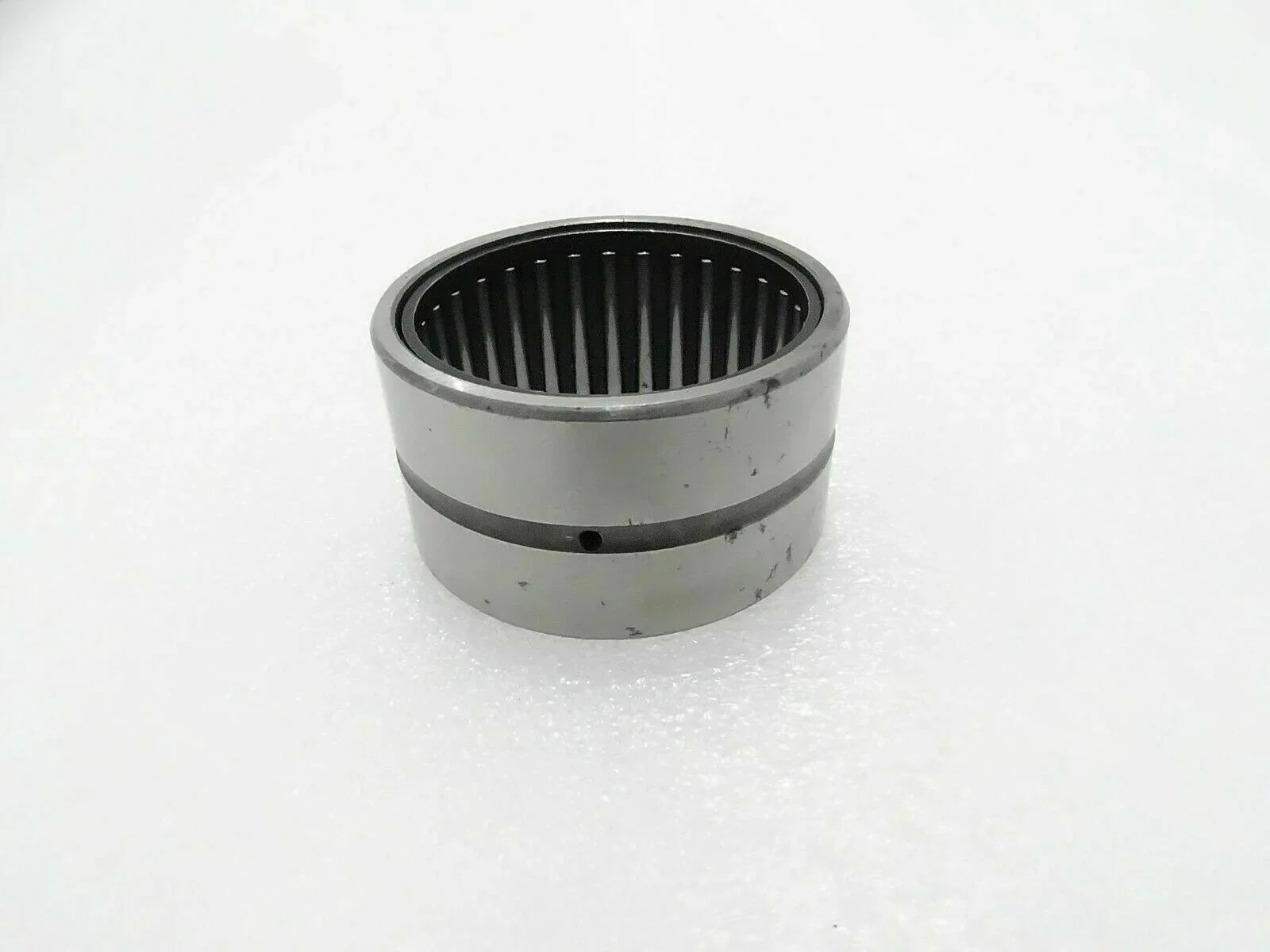 Needle bearing bushing with cylindrical metal housing and inner roller cage