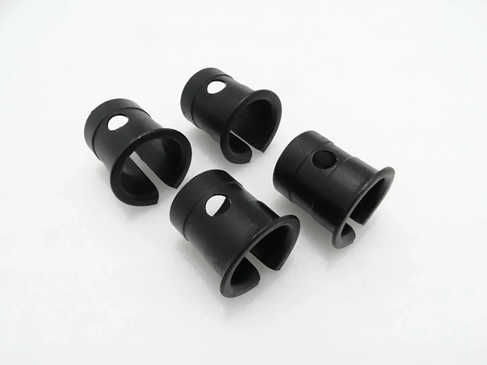 Set of four black cylindrical bushings for machine linkage