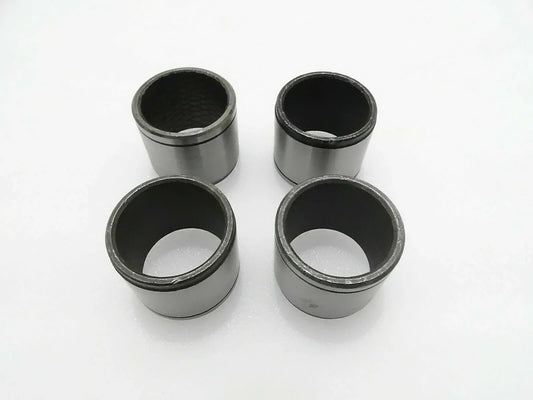 Set of 4 metal cylindrical bushes with dark inner bores