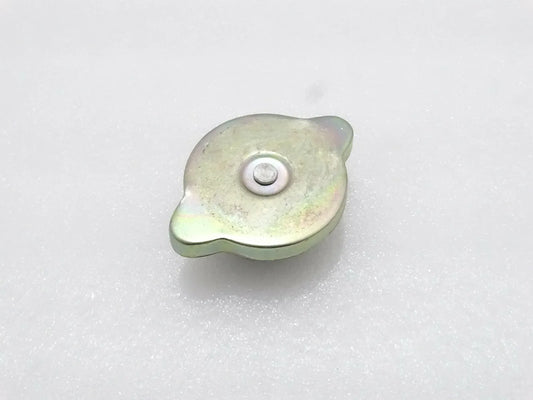 Light green metal radiator cap with circular center and mounting tab