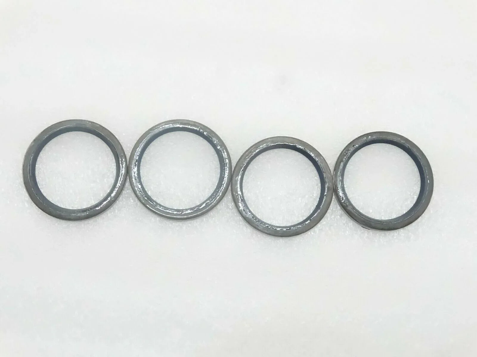 JCB seal pivot pin grease set, four durable metal rings for effective lubrication in machinery