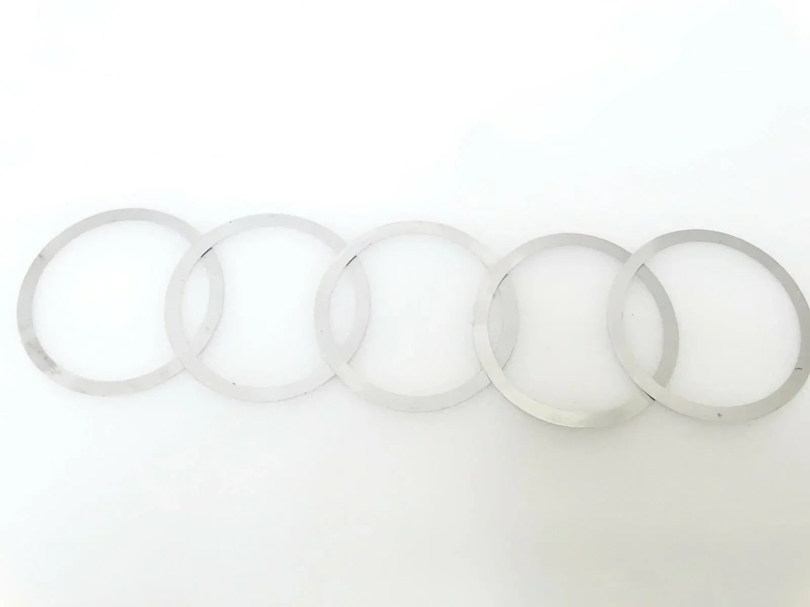 Shim kit: set of thin circular washers and rings, light gray