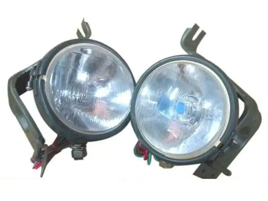 Pair of round vehicle headlights with mounting brackets and wire harnesses